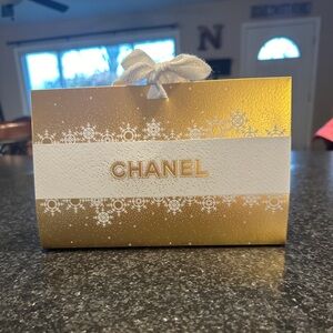 Gold Chanel holiday box with black cinch bag